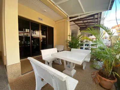 a white table and chairs in a room with plants at Kata beach Townhouse BL2 in Kata Beach