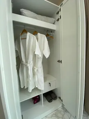 a closet with white towels hanging in it at Ta-iad homestay in Ban Suan