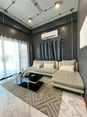 a living room with two beds and a table at Ta-iad homestay in Ban Suan
