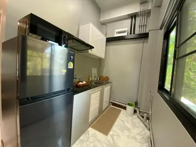 a kitchen with a large stainless steel refrigerator at Ta-iad homestay in Ban Suan