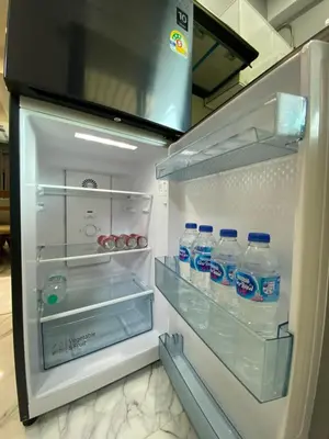 an open refrigerator with bottles of water in it at Ta-iad homestay in Ban Suan