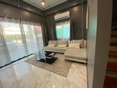 a living room with a couch and a window at Ta-iad homestay in Ban Suan