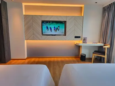 a room with a tv on a wall with a table at Super Studio La Vita 2 pool in Rawai Beach