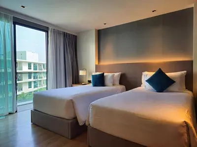 two beds in a hotel room with a large window at Super Studio La Vita 2 pool in Rawai Beach