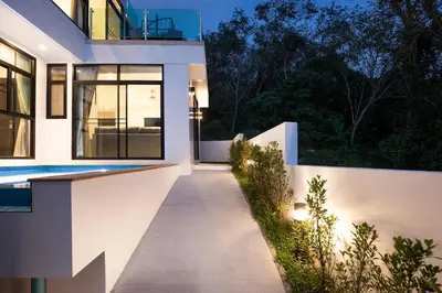 a pathway leading to a house at night at Namara The Residences B in Kamala Beach