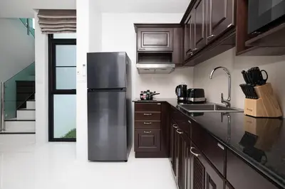 a kitchen with a stainless steel refrigerator and wooden cabinets at Namara The Residences B in Kamala Beach