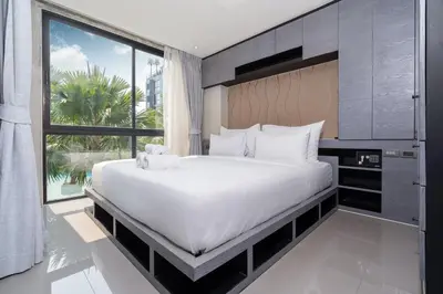 a bedroom with a large bed and a large window at Tropical Pool View 2 BR Apartment CTG B207-8 in Tropics Kamala Residence in Kamala Beach
