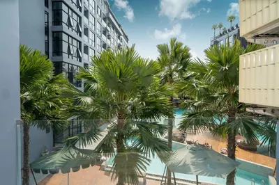 a view from the balcony of a hotel with palm trees at Tropical Pool View 2 BR Apartment CTG B207-8 in Tropics Kamala Residence in Kamala Beach