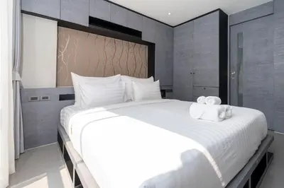 a bedroom with a large white bed with towels on it at Tropical Pool View 2 BR Apartment CTG B207-8 in Tropics Kamala Residence in Kamala Beach