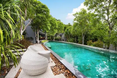 a swimming pool with chairs next to a house at Embrace Nature, Comfort & Beach Proximity - Natural Park B24 Suite, Kamala in Kamala Beach
