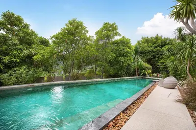 a swimming pool with trees in the background at Embrace Nature, Comfort & Beach Proximity - Natural Park B24 Suite, Kamala in Kamala Beach