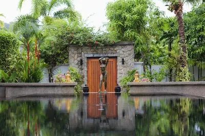 a wooden door in a garden with a pool of water at 06 - Luxurious & Lavish Getaway in Surin Beach in Surin Beach