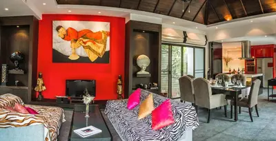 a living room with a couch and a red wall at 06 - Luxurious & Lavish Getaway in Surin Beach in Surin Beach