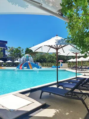a pool with chairs and an umbrella and a water park at 2 bedrooms apartment La Vita Rawai in Rawai Beach