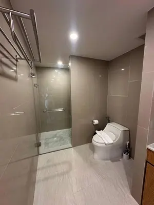 a bathroom with a toilet and a glass shower at 2 bedrooms apartment La Vita Rawai in Rawai Beach