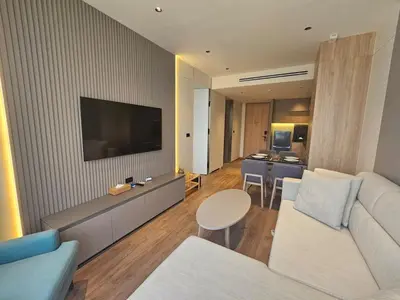 a living room with a white couch and a television at Modern apartment Layan Beach in Layan Beach