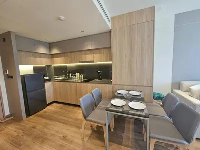 a living room with a table and chairs and a kitchen at Modern apartment Layan Beach in Layan Beach