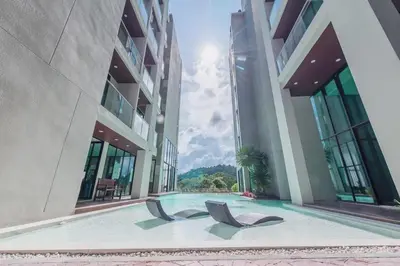 two chairs in a swimming pool in a building at Peacefull new condo Patong in Patong Beach