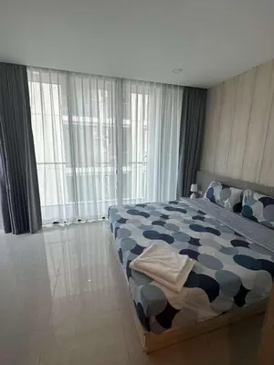 a bedroom with a bed with a blue and white comforter at Peacefull new condo Patong in Patong Beach