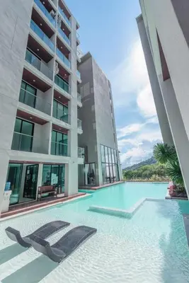 a swimming pool in front of a building at Peacefull new condo Patong in Patong Beach