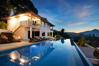 a villa with a swimming pool at night at Baan Chom View Residences in Kamala Beach