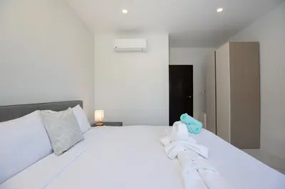 a bedroom with a white bed with towels on it at Baan Chom View Residences in Kamala Beach