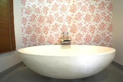 a white tub in a bathroom with a red and white wallpaper at Naiharn Beach 3 bedrooms villa in Rawai Beach