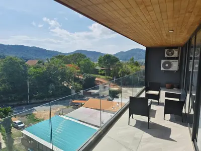 a balcony of a house with a table and chairs at Condo with Roof top sea view in Rawai Beach