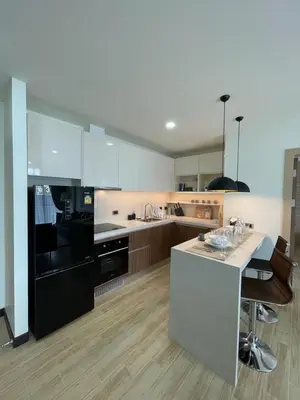 a kitchen with a black and white stove top oven at Condo with Roof top sea view in Rawai Beach