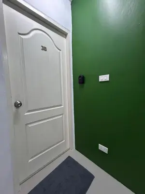 a room with a white door and a green wall at Sleepwell at naiyang No2 in Nai Yang Beach