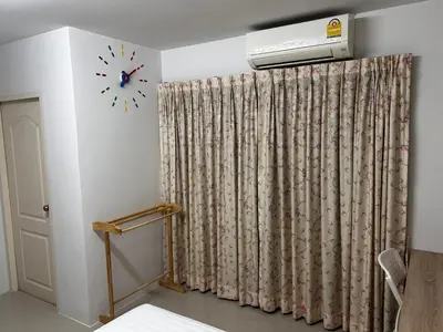 a room with a curtain and a clock on the wall at Sleepwell at naiyang No2 in Nai Yang Beach