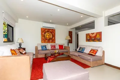 a living room with a couch and a table at Naiharn beach sands Apartment in Nai Harn Beach