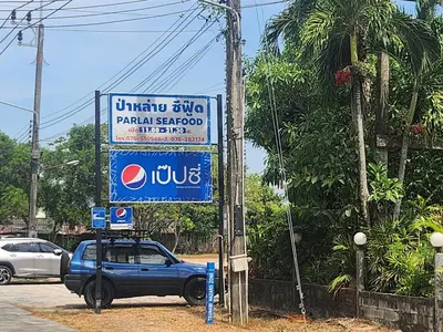 a blue car parked in front of a sign at Zen House Mono in Ban Na Bon