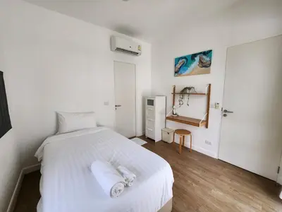 a bedroom with a white bed with towels on it at Zen House Mono in Ban Na Bon