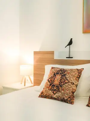 a bedroom with a white bed with a pillow on it at Place Hotel in Kata Beach
