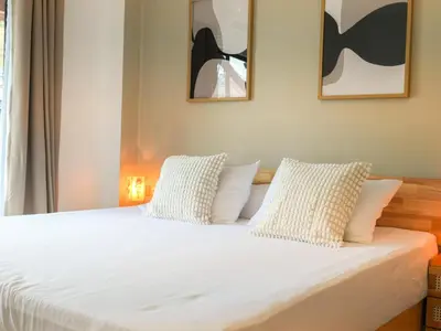 a bedroom with a bed with white sheets and pillows at Place Hotel in Kata Beach