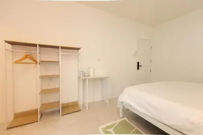 a white bedroom with a bed and a desk at Place Hotel in Kata Beach