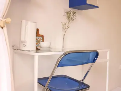 a blue chair sitting in front of a white desk at Place Hotel in Kata Beach