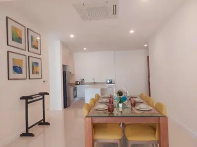 a dining room with a table and chairs and a kitchen at VIP Suite Residence At Tubkaak Beach, Krabi in Ban Ko Kwang