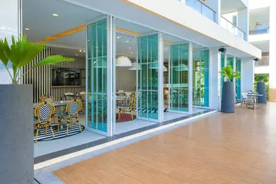 a lobby with glass walls and tables and chairs at VIP Suite Residence At Tubkaak Beach, Krabi in Ban Ko Kwang