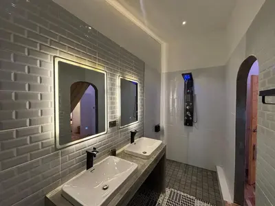 a white bathroom with a sink and a mirror at The beach house in Surin Beach