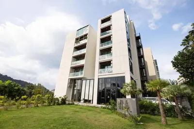 a large white building with palm trees in front of it at Tropical Seaview Studio A601 at VV Patong, Just 5 Min Drive from Patong Nightlife in Patong Beach