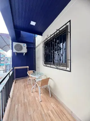 a table and chairs in a room with a blue ceiling at Kata walk&wave hostel in Kata Beach