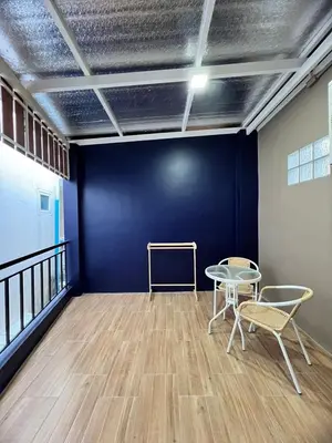 a room with a blue wall and two chairs and a table at Kata walk&wave hostel in Kata Beach