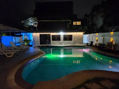 a swimming pool at night in front of a house at Baan Nur Nur 201 in Surin Beach