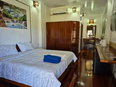 a bedroom with a bed with a blue bag on it at Baan Nur Nur 201 in Surin Beach