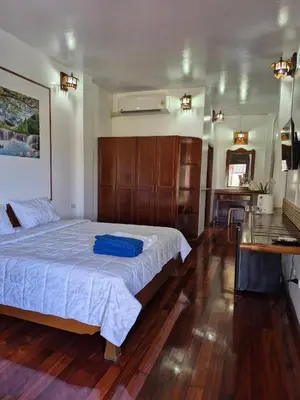 a bedroom with a large bed with a blue suitcase on it at Baan Nur Nur 201 in Surin Beach