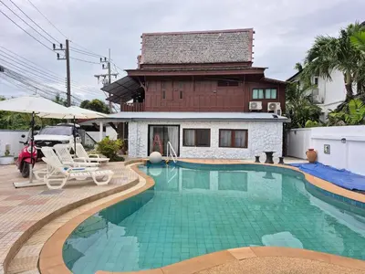 a house with a swimming pool in front of a house at Baan Nur Nur 201 in Surin Beach