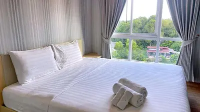 a bed with towels on it with a window at spacious and modern Apartment in Ao Nang in Ban Khlong Haeng