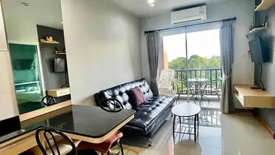 a living room with a couch and a table and a balcony at spacious and modern Apartment in Ao Nang in Ban Khlong Haeng